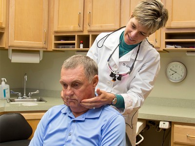 Dr. Grimshaw examining male patient's jaw