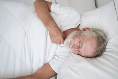 mature man sleeping peacefully in bed