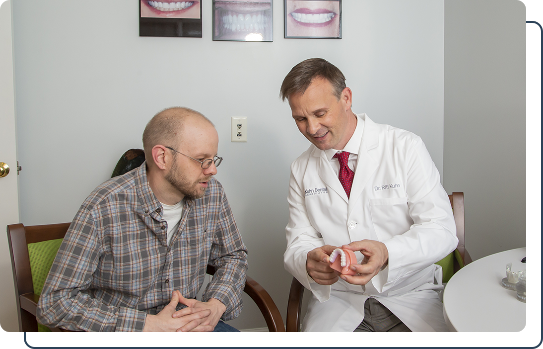 Dr. Ritt Kuhn explaining tooth replacement options with a patient