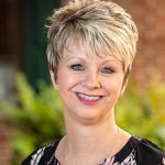 LorettaH-min (1) Women with short hair and braces smiling