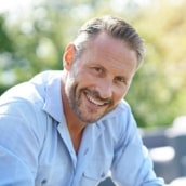 services-sleep-apnea-min Smiling man outdoors, representing improved health and energy after sleep apnea treatment.