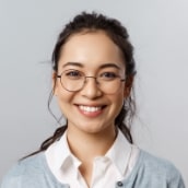 services-tmj-min Smiling woman in glasses, representing successful results of TMJ treatment.